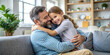© Wasi - Happy Father and Daughter Hugging on Couch at Home