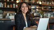 © Lush Diaries - Smiling Hispanic businesswoman working on laptop in a cafe