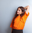 © nastia1983 - Beautiful young happy woman in casual clothing looking up in orange casual shirt on blue studio background on empty copy space. Closeup