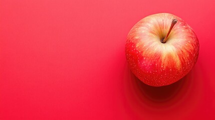 A fresh mammee apple on a vibrant red background, leaving space for text.