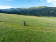 © lzf - woman riding mountain bike on beautiful flowering grassland mountain top