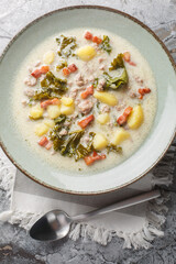 Wall Mural - Tuscan Soup made with Italian sausages, kale, potatoes, onion, and garlic closeup on the plate on the table. Vertical top view from above