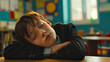© chekart - A tired, bored student fell asleep in class. The boy is sleeping in the classroom. The boy is wearing a school suit. School education is too difficult