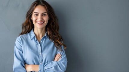 Wall Mural - Happy young smiling confident professional business woman wearing blue shirt, pretty stylish female executive looking at camera, standing arms crossed isolated at gray background