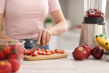 Sticker - Woman making delicious smoothie with blender at white marble table in kitchen, closeup