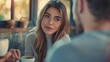 © Kerah - Beautiful woman is having a serious conversation with her partner while holding a cup of coffee.