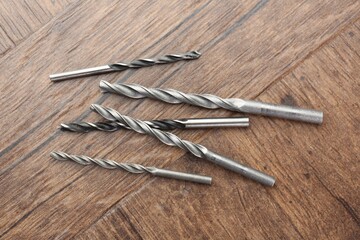 Poster - Many different drill bits on wooden surface, top view