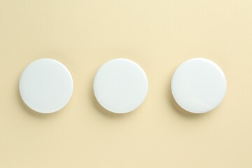 Wall Mural - White button badges on beige background, flat lay. Mockup for design