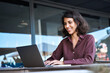 © Stock 4 You - Smiling middle eastern indian woman working remotely online on business project. Young hispanic or muslim freelance female student worker using laptop for studying sitting outdoors at office building