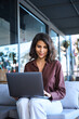 © Stock 4 You - Vertical portrait beautiful middle eastern indian girl freelancer working on remote business project. Young latin, arabian freelance woman using laptop app for studying, shopping sit outdoors at cafe