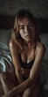 © Gary - A woman in lingerie sitting on a bed