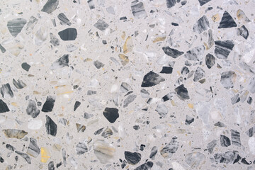 Aufkleber - A stone floor with a lot of black and white stones. The floor is very textured and has a lot of different shapes and sizes