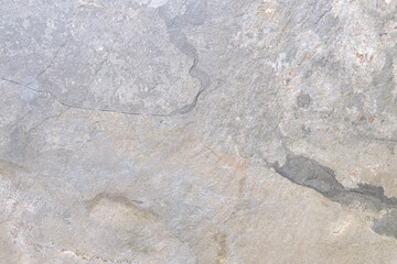 Aufkleber - A gray stone wall with a few cracks. The wall is rough and uneven, with some areas looking like they have been chipped away. Scene is somewhat somber and desolate, as the wall appears to be old
