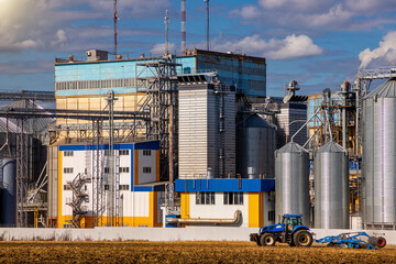 Agricultural Silos. Storage and drying of grains, wheat, corn, soy, sunflower against the blue sky with white clouds.Storage of the crop