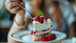 © Mirjana - Customer enjoying a slice of creamy raspberry dessert at a cozy café in the afternoon