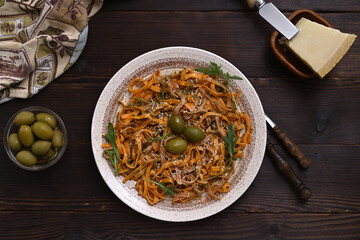 delicious dinner pasta with pesto, olives and hard cheese on the table