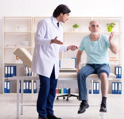 Wall Mural - Old man visiting young male doctor