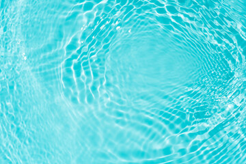 Blue water with ripples on the surface. Defocus blurred transparent blue colored clear calm water surface texture with splashes and bubbles. Water waves with shining pattern texture background.