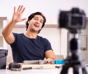 Wall Mural - Young male repairman recording video for his blog