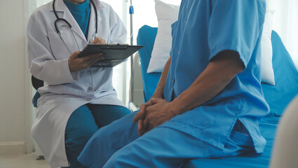 Young female doctors and nurses help to talk to happy elderly male patients giving consultations in the hospital. Caring, encouraging, and comforting mature men. health care concept