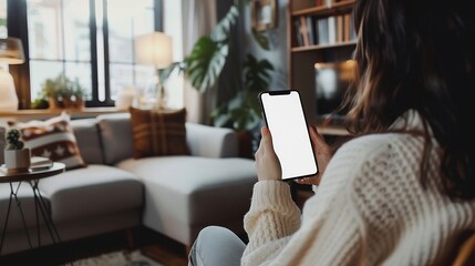 Poster - Mockup image of a woman holding and using mobile phone with blank desktop white screen at home : Generative AI