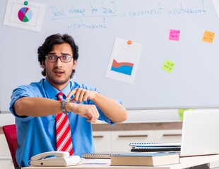 Wall Mural - Young male financial manager working in the office