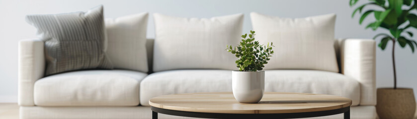 Sticker - Minimalistic living room with a white sofa, wooden coffee table, and potted plant; modern interior design with natural light and simple decor.