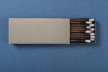 Wall Mural - top view grey color matchbox and grey match sticks on a blue background