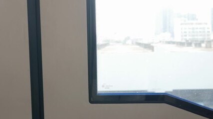 Canvas Print - view though skytrain window while train is running with view of bangkok city skyline in summer daytime,transportation traveling background