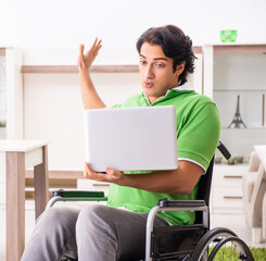 Wall Mural - Young handsome man in wheelchair at home