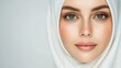 © red_orange_stock - A poised woman in a white hijab gazes confidently with captivating blue eyes