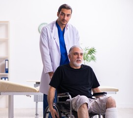 Wall Mural - Old injured man visiting young male doctor traumatologist