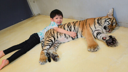 happy cute boy hug tiger cub in the zoo