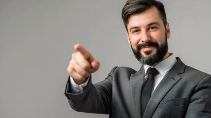 Happy businessman isolated on gray background, corporate business manager positive entrepreneur or boss with smiling cheerful face expression pointing with finger on blank copy space for advertising 