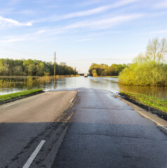 A road is flooded with water and a truck is driving down it