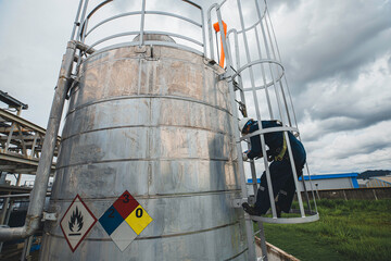 Wall Mural - Male worker climbs up the ladder inspection stainless tank