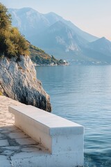 Canvas Print - A white bench sits on a rocky shore overlooking the ocean