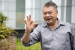 © 9nong - Happy smiling Asian middle aged old man showing approving, good, yes, ok hand gesture