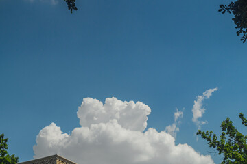 Wall Mural - fluffy white clouds against a clear blue sky. relaxing natural scene, blank for artwork. in the fore