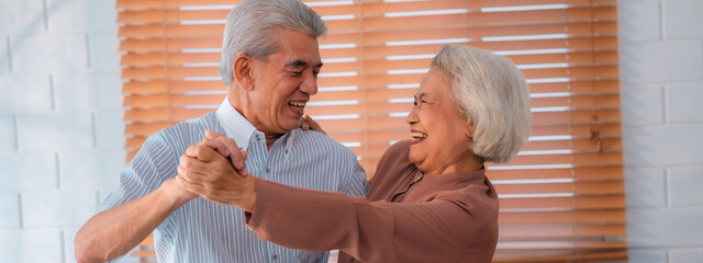 Wall Mural - Celebrating Retirement: Elderly Couple Embrace Love and Happiness at Home, Fun-filled Life of Dancing, Smiling, and Bonding Together, Cherishing Family and Romance in Their Golden Years