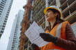 © Татьяна Евдокимова - Construction site supervisor is holding blueprints and inspecting the progress of a building project