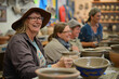 © Татьяна Евдокимова - Senior woman happily shapes clay into pottery with friends in a cozy workshop, learning and enjoying the craft together in an artistic studio