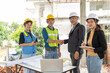 © suwanb - Construction teamwork, Engineer building, Civil Engineer, Contractor and Architect shake hand in construction site.