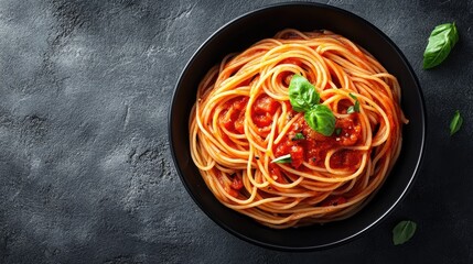 Poster - Elegant black bowl of spaghetti with tomato sauce, captured from above with a grey stone background, showcasing a classic Italian dish