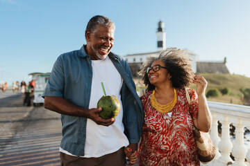 Happy senior couple enjoying holiday with a coconut drink