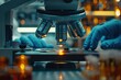 © sornthanashatr - A person is looking through a microscope at a slide