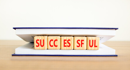 Successful symbol. Concept word Successful on beautiful wooden cubes in book. Beautiful wooden table white background. Business successful concept. Copy space.