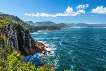 Wall Mural - A serene landscape featuring the ocean and surrounding mountains, great for nature-inspired designs