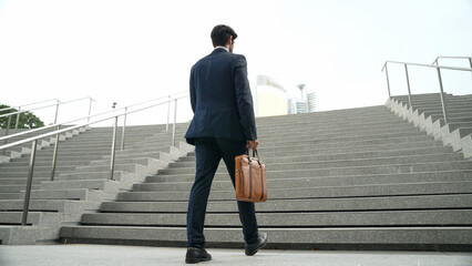 Wall Mural - Top view of smart business man walking up stairs with bag in the hand. Professional project manager climb up the stair and going to workplace. Increasing skill, getting promotion, traveling. Exultant.