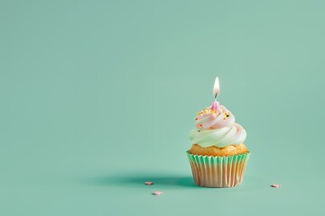 Cupcake with lit candle on green background